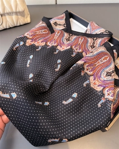 Detailed texture of luxury silk scarf with paisley and polka dot print on black background