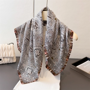 Elegant paisley herringbone cotton-linen feel scarf draped on a minimalist white hanger