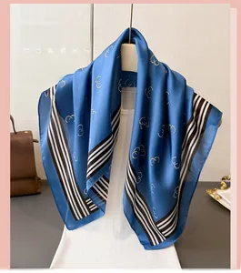 Detail of navy blue silk scarf with geometric prints and striped borders on display