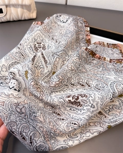 Close-up of luxury paisley pattern scarf with elegant drape on minimalist background