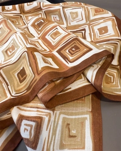 Detailed view of the geometric brown and beige textured weave on a cotton-linen scarf