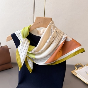 French style printed silk square scarf with geometric pattern tied on a wooden hanger