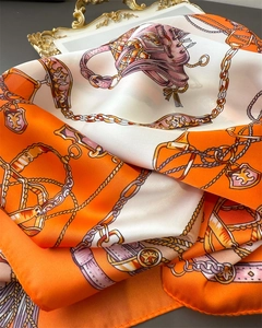 Detail of silk scarf with equestrian chain print and golden harness patterns