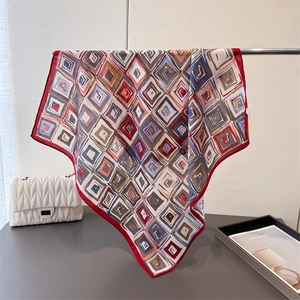 Elegant geometric patterned scarf with red accents displayed on a metal stand