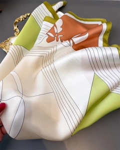Close-up of silk-textured scarf showing vibrant geometric patterns and floral motifs