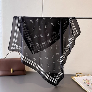 Detail of silk-like square scarf with geometric prints and striped borders on display