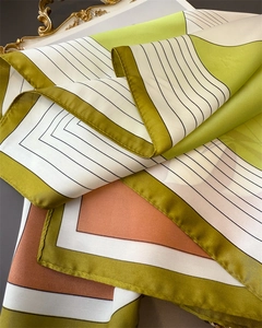 Detail of French style satin scarf featuring geometric print and rolled hem edge