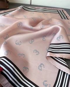 Close-up of geometric pattern silk scarf with elegant pink texture and striped edges