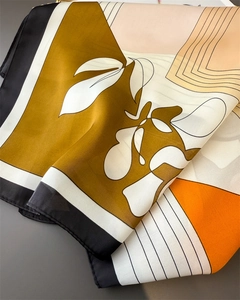 Detailed view of silk square scarf featuring abstract floral lines and rolled edges