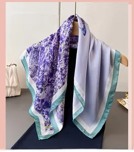 Detail of lavender floral and butterfly print silk scarf hung on a wooden hanger