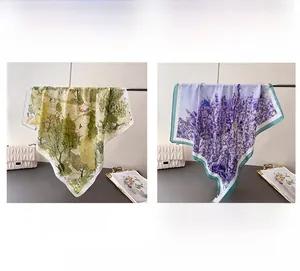 Detail view of silk scarves in green forest and purple lavender patterns hanging on a metal rod