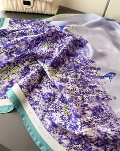 Detailed close-up of lavender floral silk scarf with butterfly print and mint green border