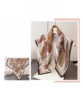 Detail of silk-like square scarf featuring geometric patterns and elegant belt motifs