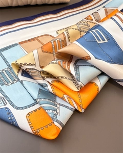 Detail of silk-like scarf featuring colorful geometric patterns and smooth texture