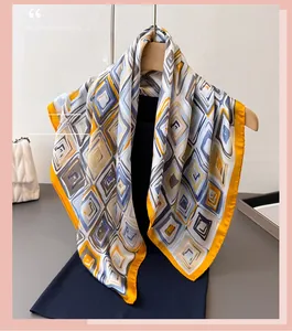 Detail of geometric rhombus pattern silk scarf hanging on a wooden hanger with yellow borders