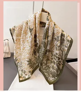 Detailed texture of botanical print silk scarf featuring green flowers and bird patterns