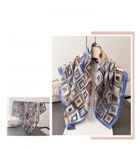 Detailed close-up of geometric silk scarf with navy and caramel square pattern accents