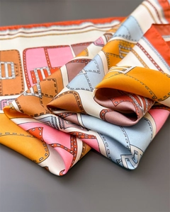 Detailed view of luxury orange silk scarf with geometric print and smooth texture
