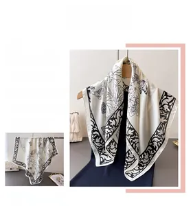 Detail of silk-like scarf with black and white floral prints and vintage border patterns