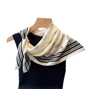 Elegant silk scarf with geometric horseshoe print on wooden hanger with navy vest
