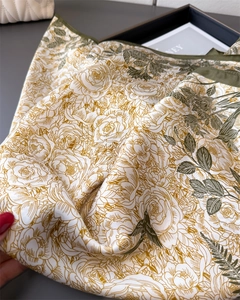 Detail of floral silk scarf featuring vintage rose and bird patterns with soft drapes