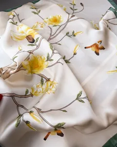 Detail of silk scarf showing floral magnolia print and premium satin texture folds