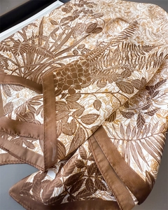 Macro shot of faux silk scarf with botanical print and smooth satin texture finish