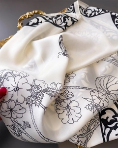 Close-up of elegant floral print silk square scarf with delicate texture and sheen