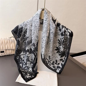 Elegant black and white floral silk scarf with rose and bird print styled on a white top
