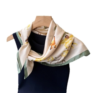 Floral silk square scarf featuring orange birds and green borders on a beige base