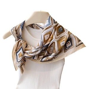 Brown geometric print silk scarf displayed on a white knit sweater with a satin finish