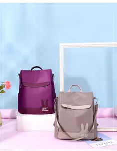 Detail view of purple and khaki nylon backpacks with cute rabbit ears on the bottom
