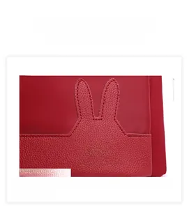 Detail of red backpack featuring decorative rabbit ears and lychee grain leather texture