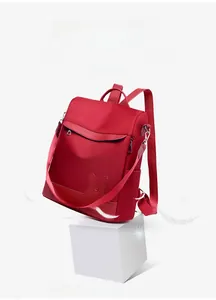 Detail of red nylon backpack with rabbit ear patches and lightweight material on display