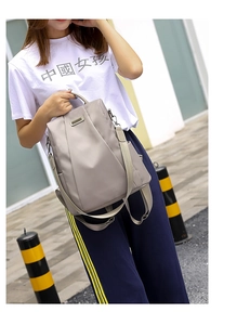Detail view of grey anti-theft waterproof oxford backpack with dual handles and side pocket