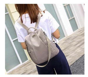 Detail of khaki anti-theft oxford backpack showing waterproof fabric and silver hardware
