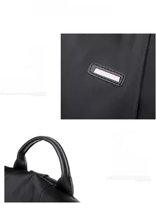 Close-up of the reinforced top handle and square buckle on black Oxford anti-theft backpack