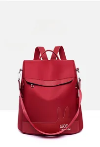 Detailed front view of a red nylon backpack with cute bunny ears and zip pocket