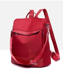 Side view of red water-resistant nylon backpack featuring cute rabbit ear details
