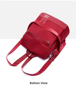 Bottom view of red waterproof nylon backpack with leather accents and metal buckles