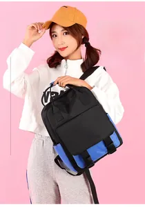 Detail view of a color-block nylon student backpack with buckled flap pockets on a model