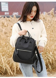 Detail view of durable black oxford cloth backpack with smooth metal zipper and leather puller