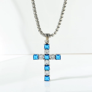 Detail of square-cut blue and white zircon stones set in a silver cross pendant necklace
