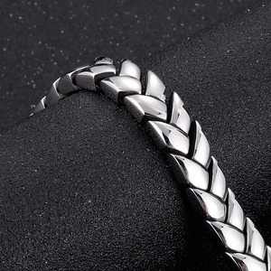Macro detail of polished stainless steel wheat chain bracelet with a sleek silver finish