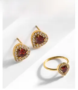 Détail de l'ensemble boucles d'oreilles et bague cœur en or avec rubis rouge et zircon
