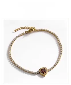 Détail d'un bracelet de tennis doré avec pierre cœur rubis et pavé de zircons brillants
