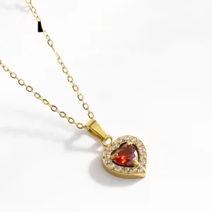 Gros plan du pendentif cœur en pierre rouge avec halo de zircons sur chaîne dorée