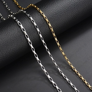 Polished silver and gold stainless steel box chain necklaces displayed on leather
