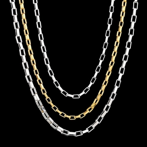 Macro detail of polished stainless steel box chains in silver and gold finishes