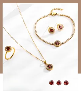 Détails de la parure dorée avec collier, bracelet, boucles d'oreilles et zircon rouge